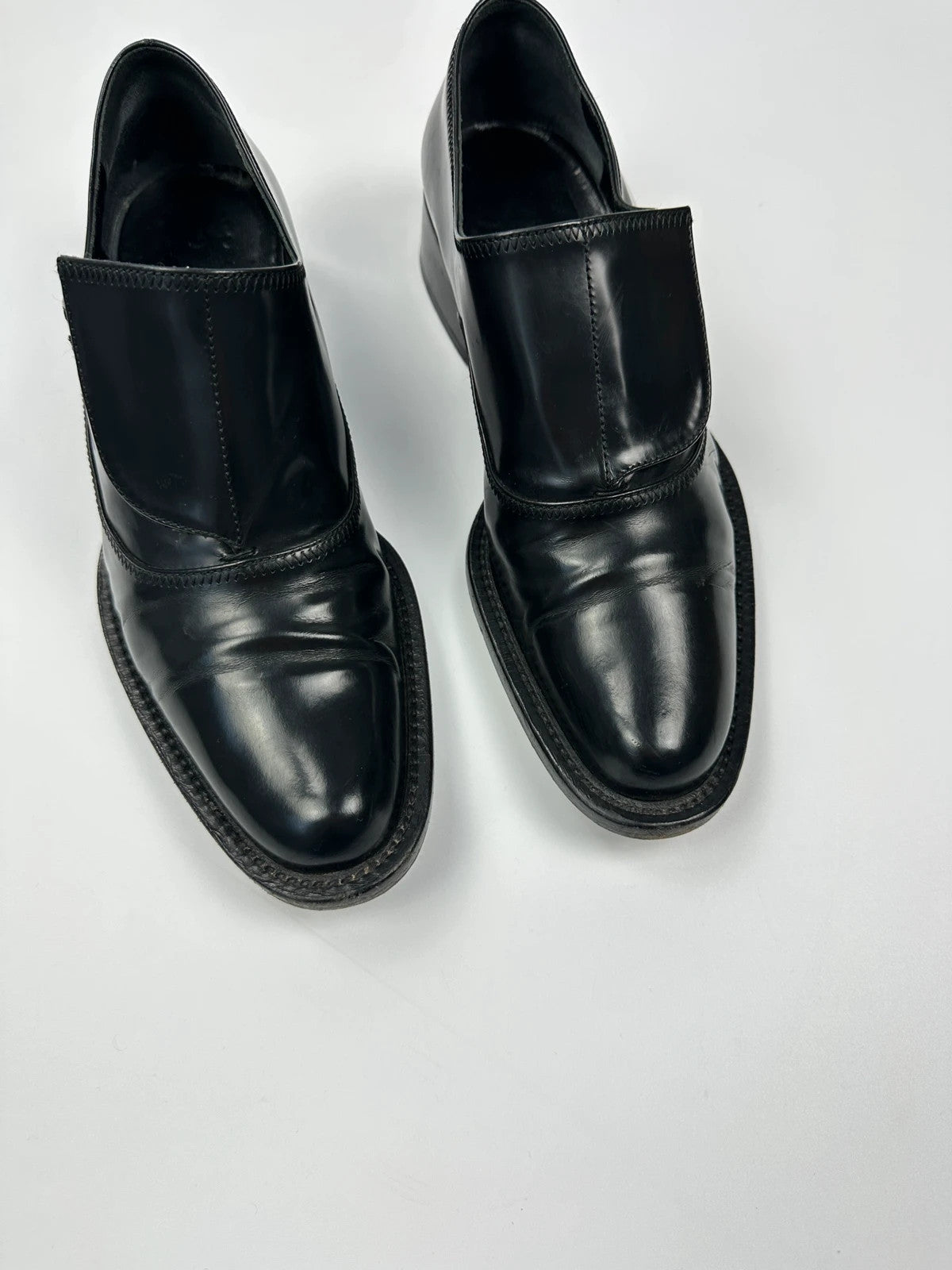 Prada black vernis loafers with pointy toe and subtle logo detailing.