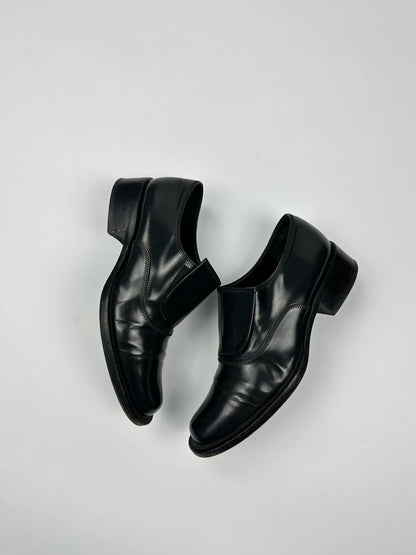 Prada black vernis loafers with pointy toe and subtle logo detailing.