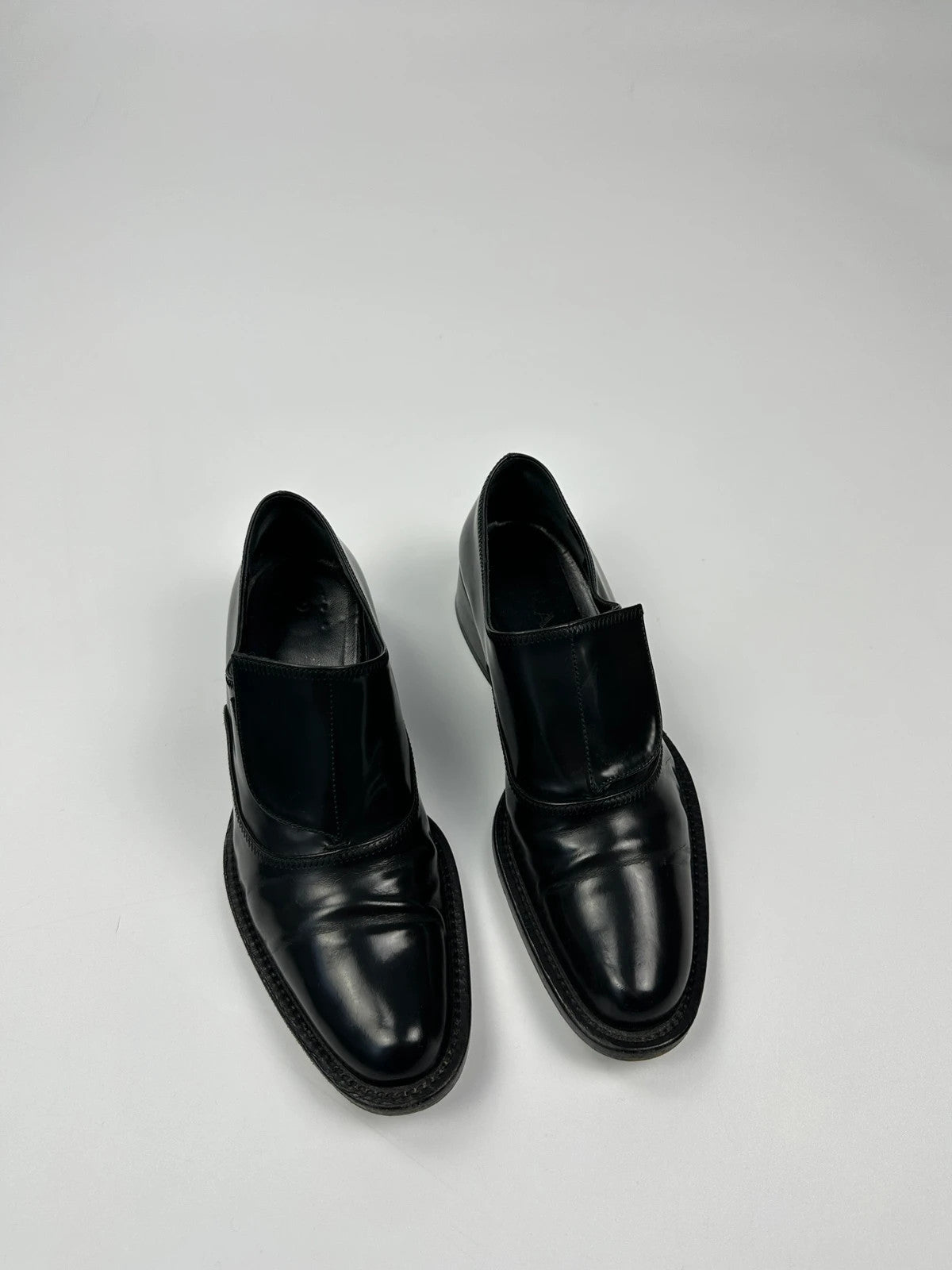 Prada black vernis loafers with pointy toe and subtle logo detailing.