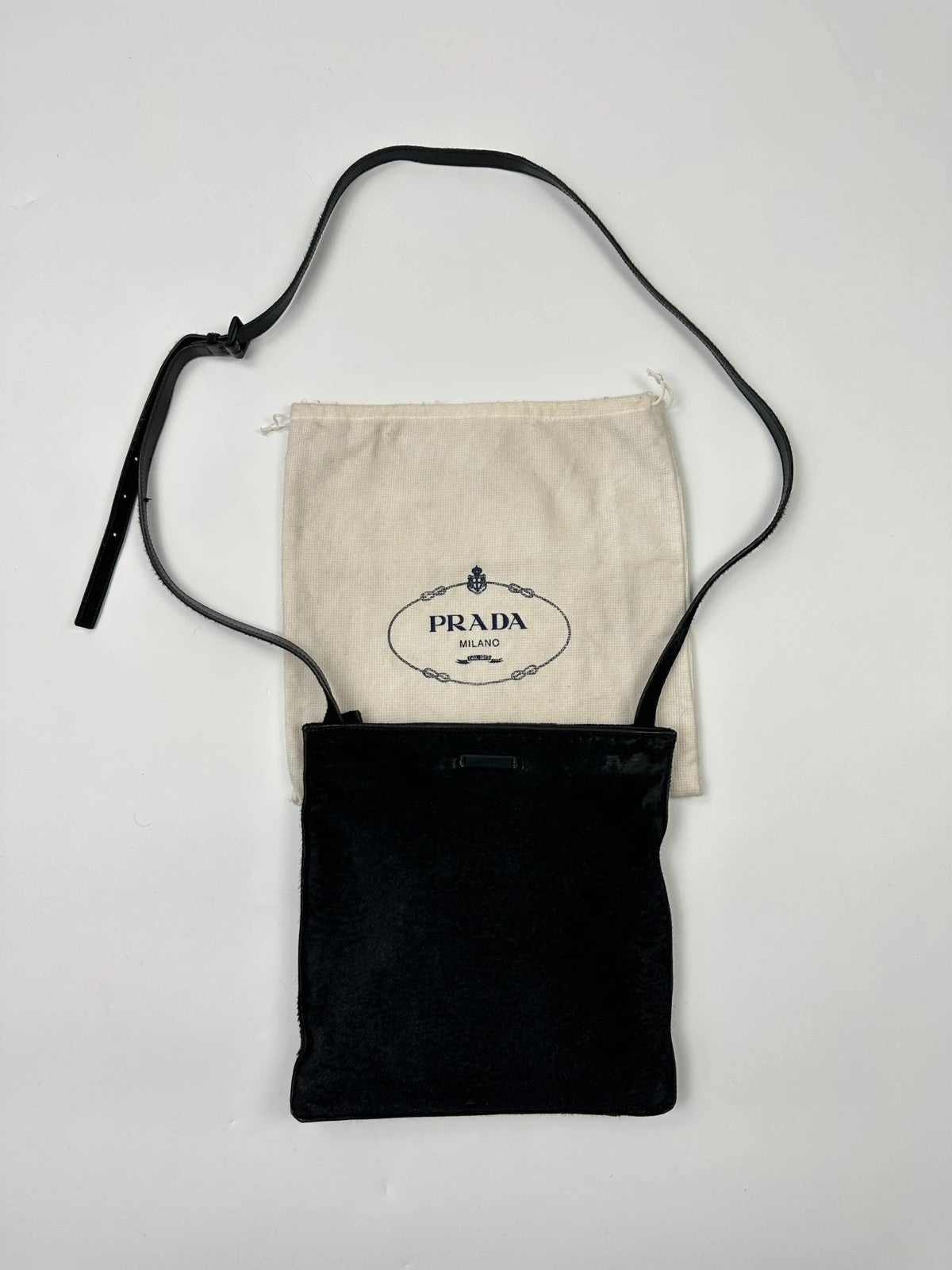 Prada black leather crossbody bag with fur accents and embossed logo.