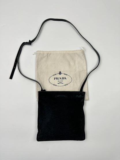 Prada black leather crossbody bag with fur accents and embossed logo.