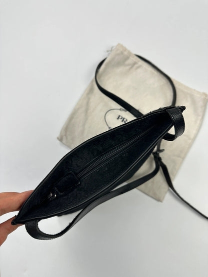 Prada black leather crossbody bag with fur accents and embossed logo.
