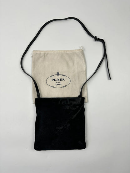 Prada black leather crossbody bag with fur accents and embossed logo.