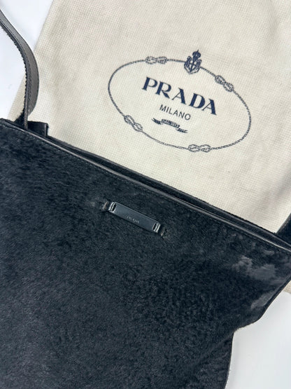 Prada black leather crossbody bag with fur accents and embossed logo.