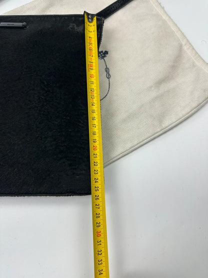 Prada black leather crossbody bag with fur accents and embossed logo.