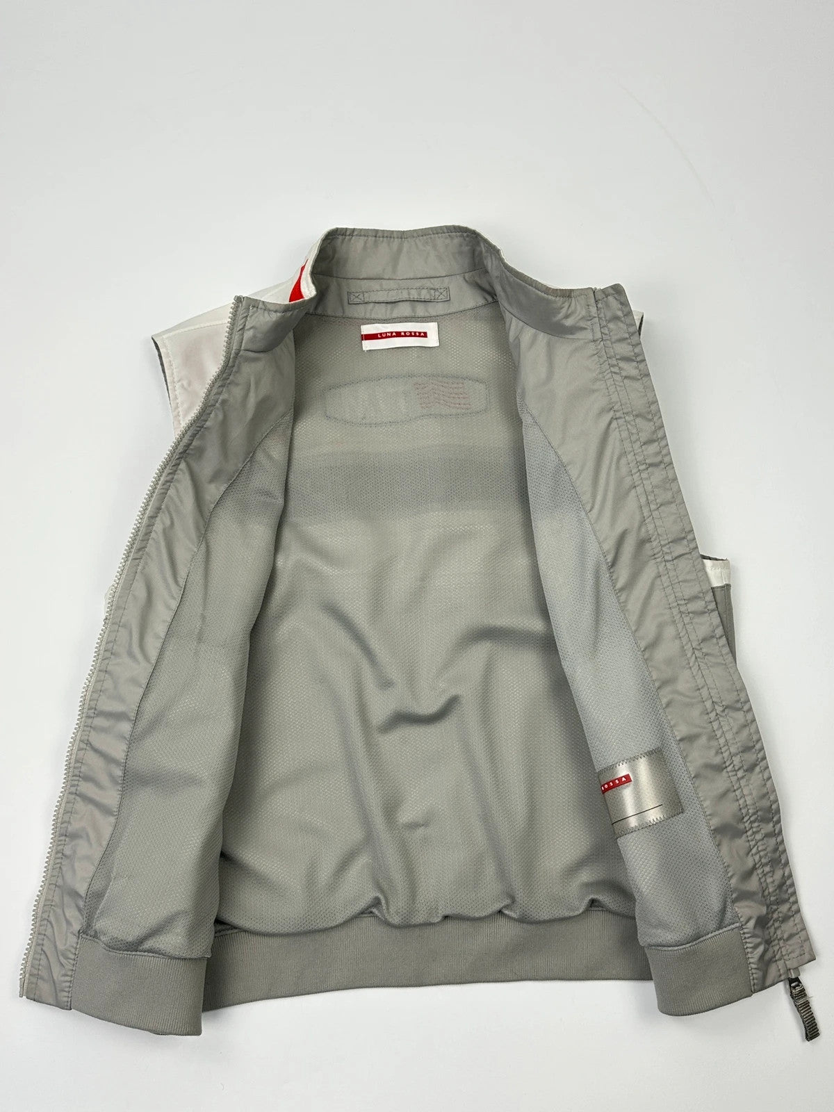 Prada red racing vest with white Luna Rossa logo and minimalist design.