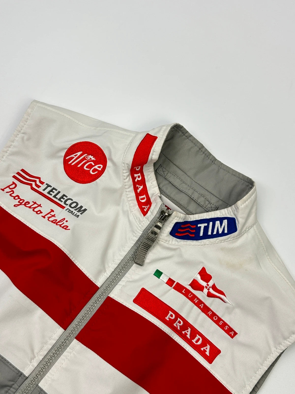 Prada red racing vest with white Luna Rossa logo and minimalist design.