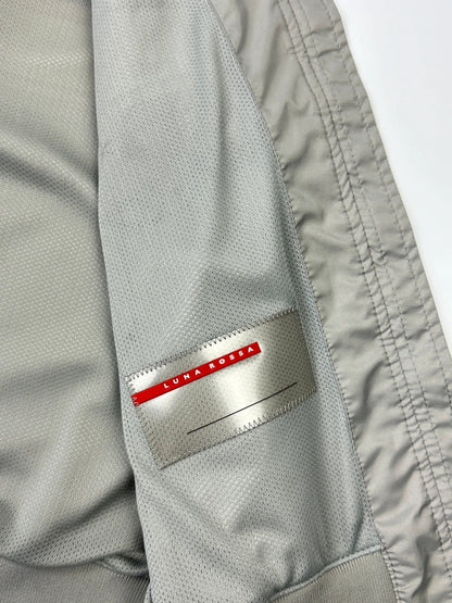 Prada red racing vest with white Luna Rossa logo and minimalist design.