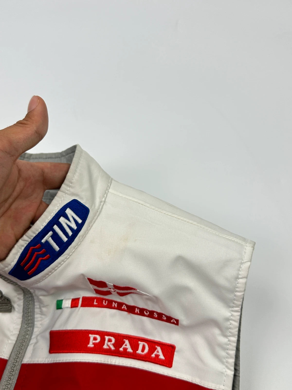Prada red racing vest with white Luna Rossa logo and minimalist design.