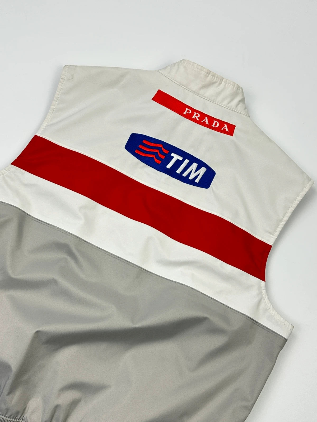 Prada red racing vest with white Luna Rossa logo and minimalist design.