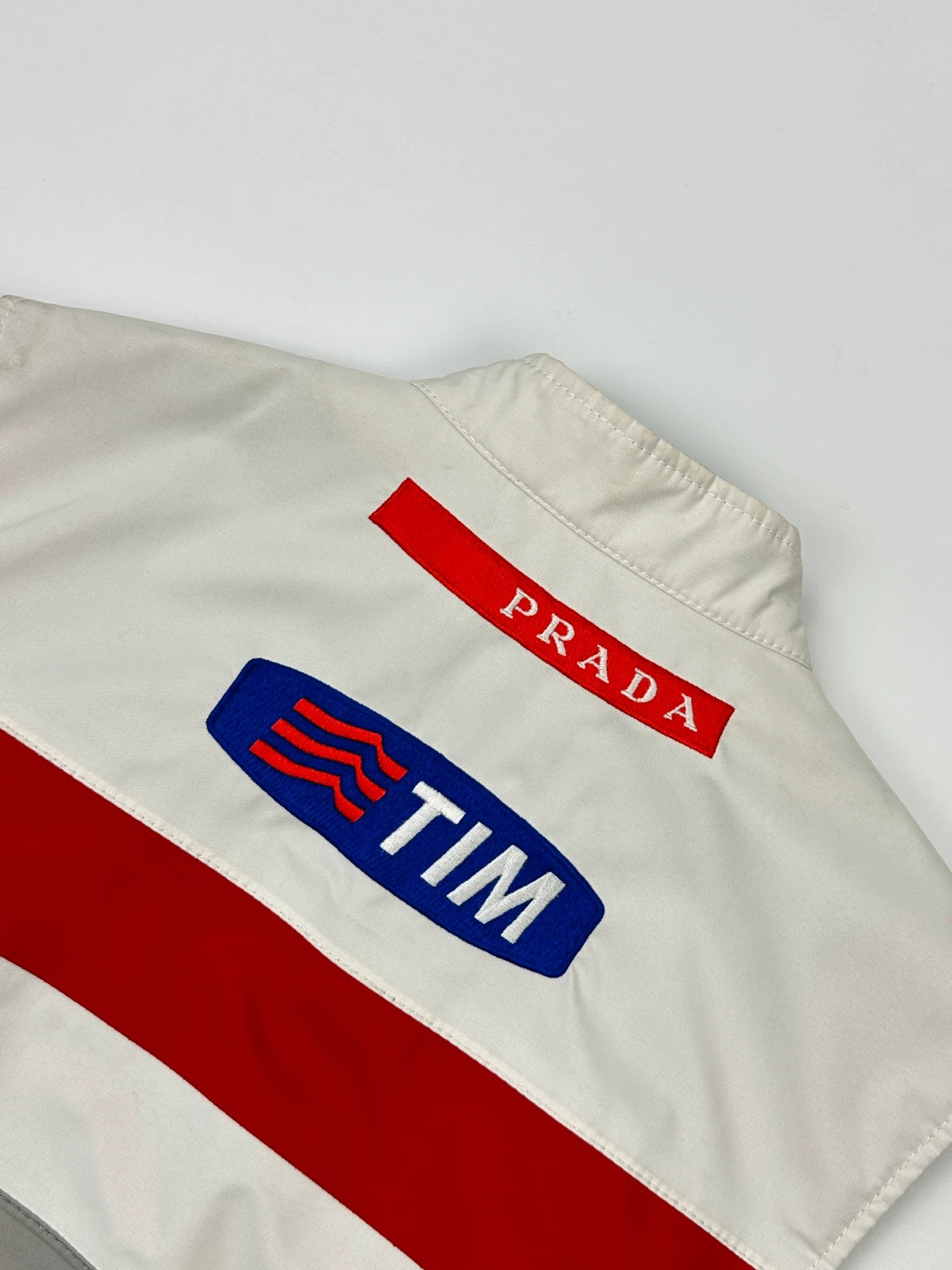 Prada red racing vest with white Luna Rossa logo and minimalist design.
