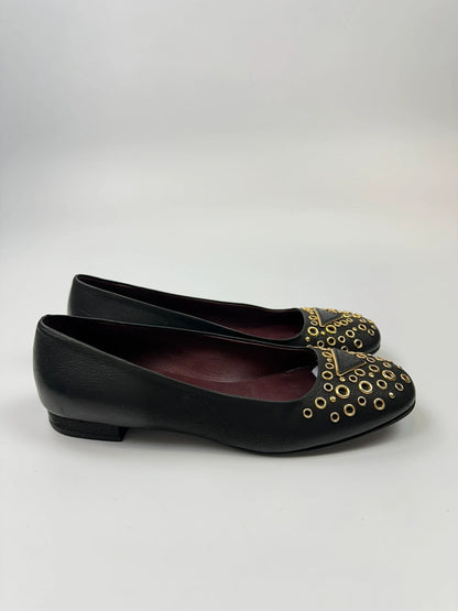 Prada black grained leather loafers with gold eyelets and triangle logo.