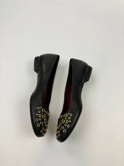 Prada black grained leather loafers with gold eyelets and triangle logo.
