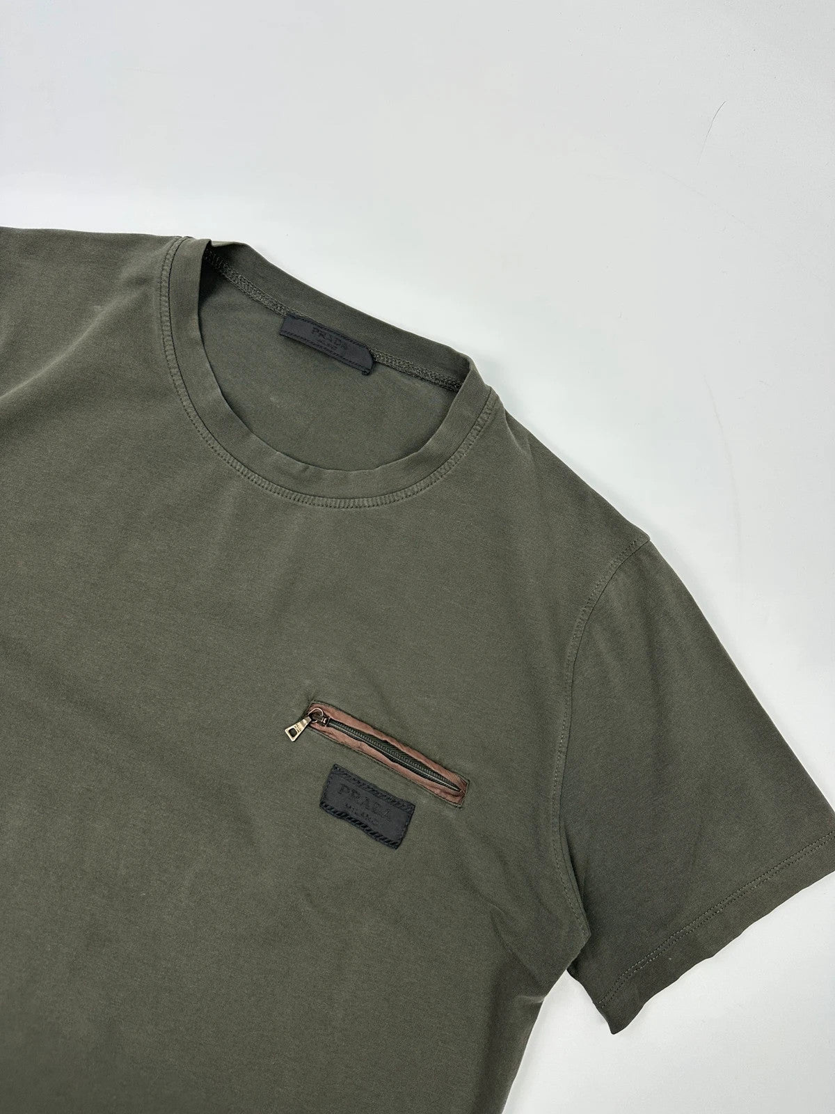 Prada khaki graphic t-shirt featuring zip chest pocket and minimalist design.
