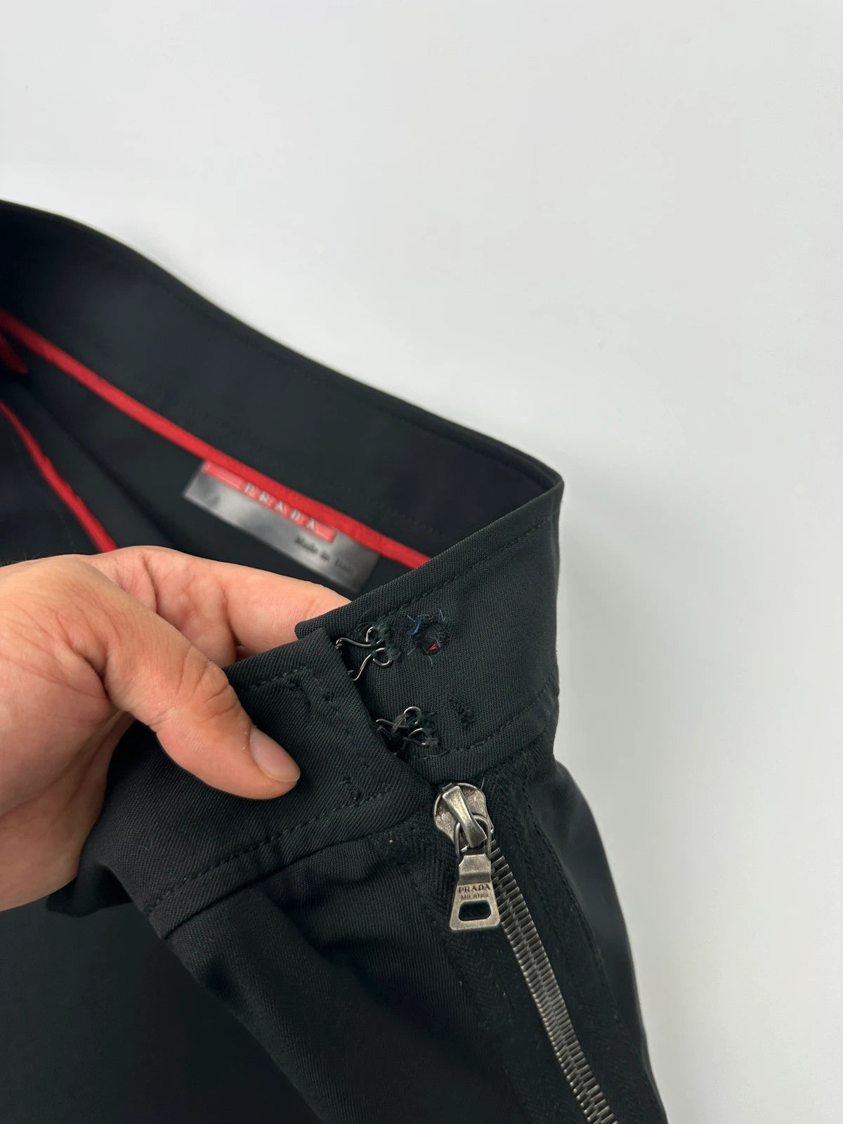 Prada black wool mid-length skirt with minimalist design and linearossa logo.