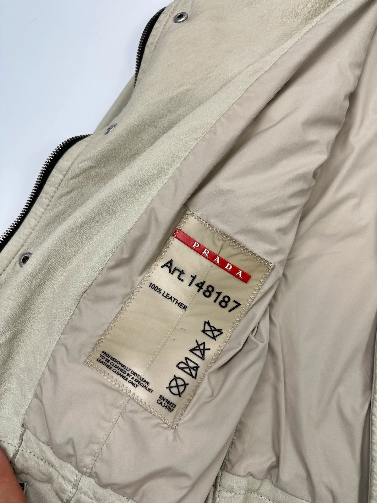 Prada beige leather fitted jacket with multi pockets and logo detailing.