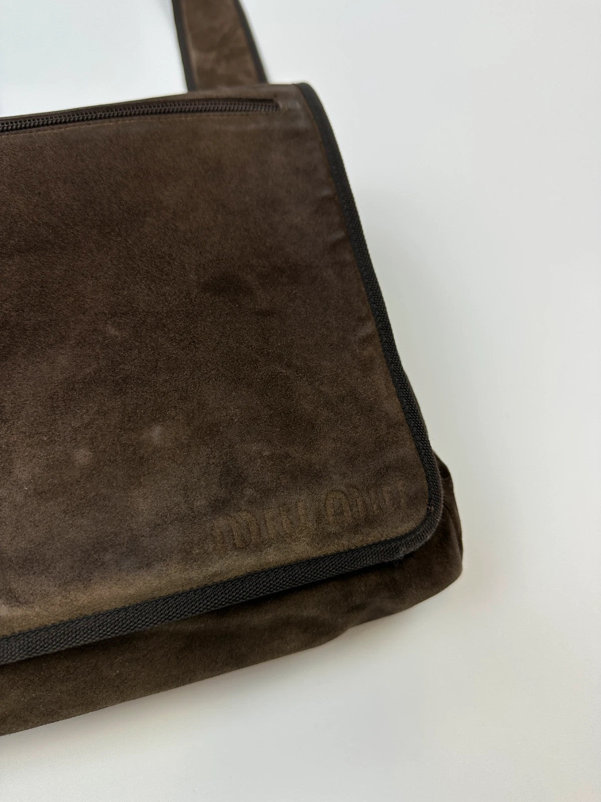 Miu Miu brown suede and mesh crossbody bag with logo detail and vintage design.