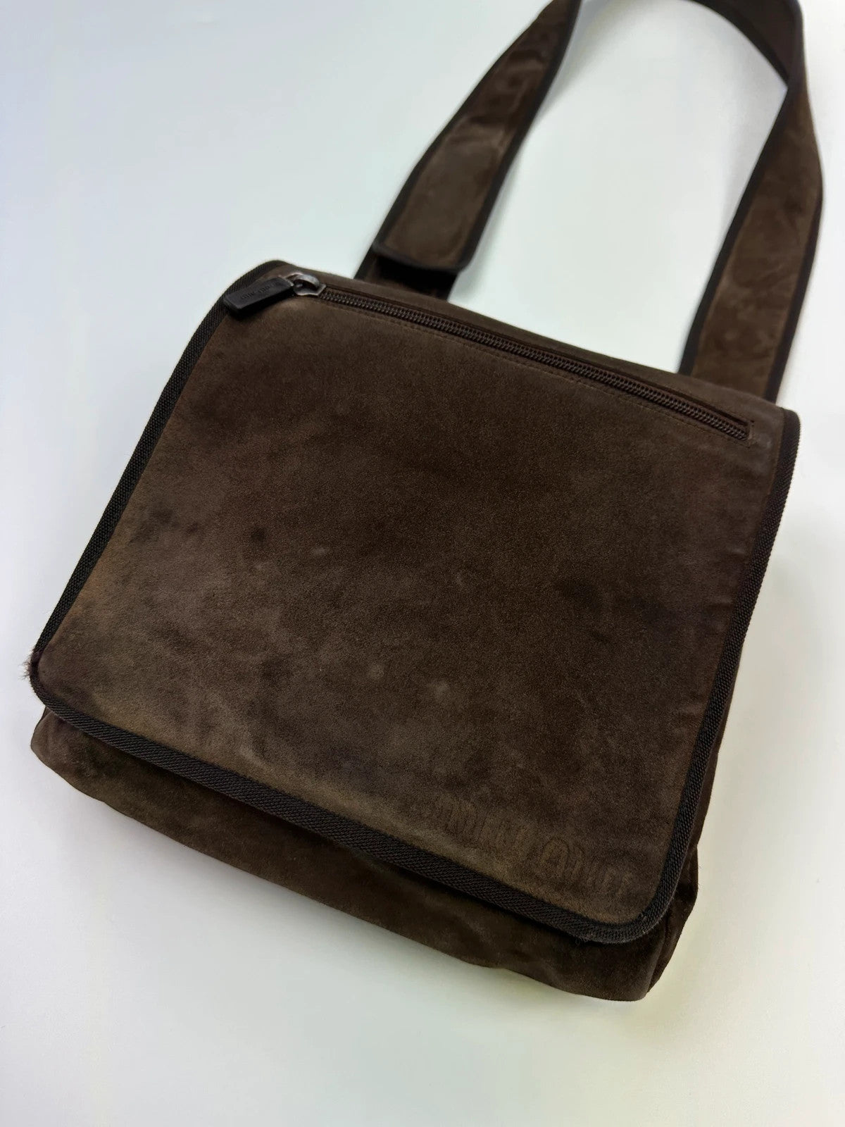 Miu Miu brown suede and mesh crossbody bag with logo detail and vintage design.