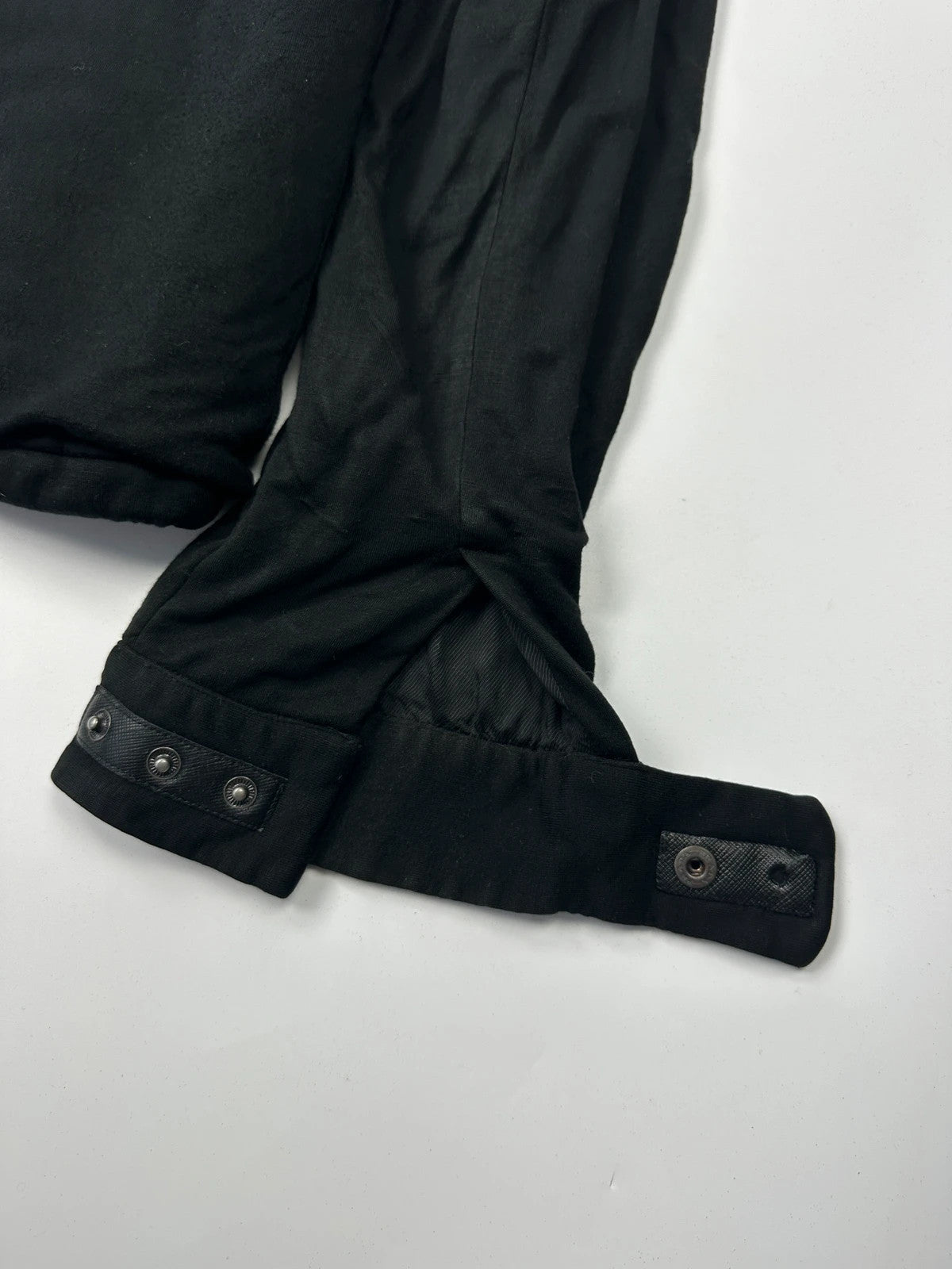 Prada black padded hooded jacket with 90s-inspired patch and braided drawstrings.