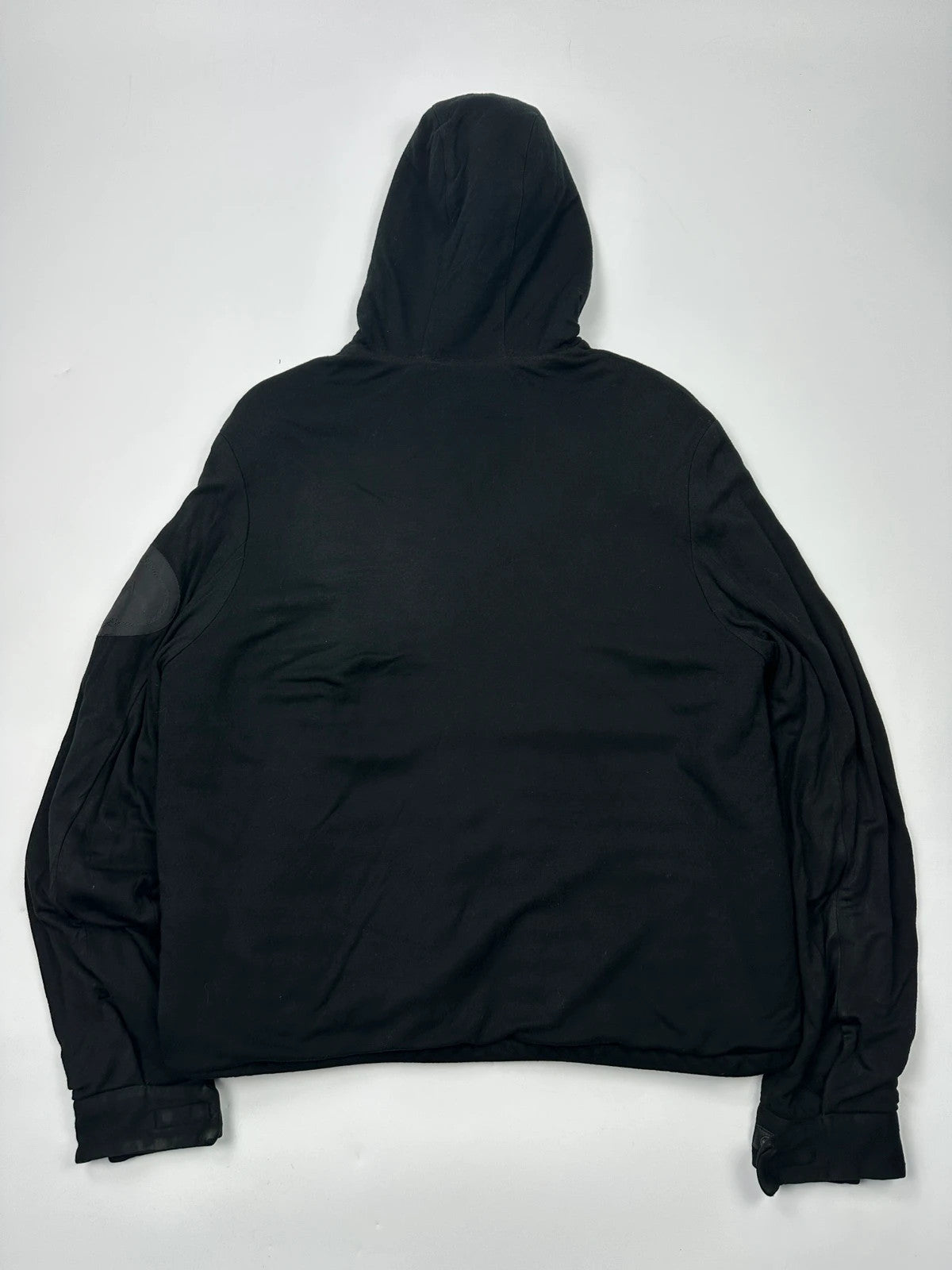 Prada black padded hooded jacket with 90s-inspired patch and braided drawstrings.