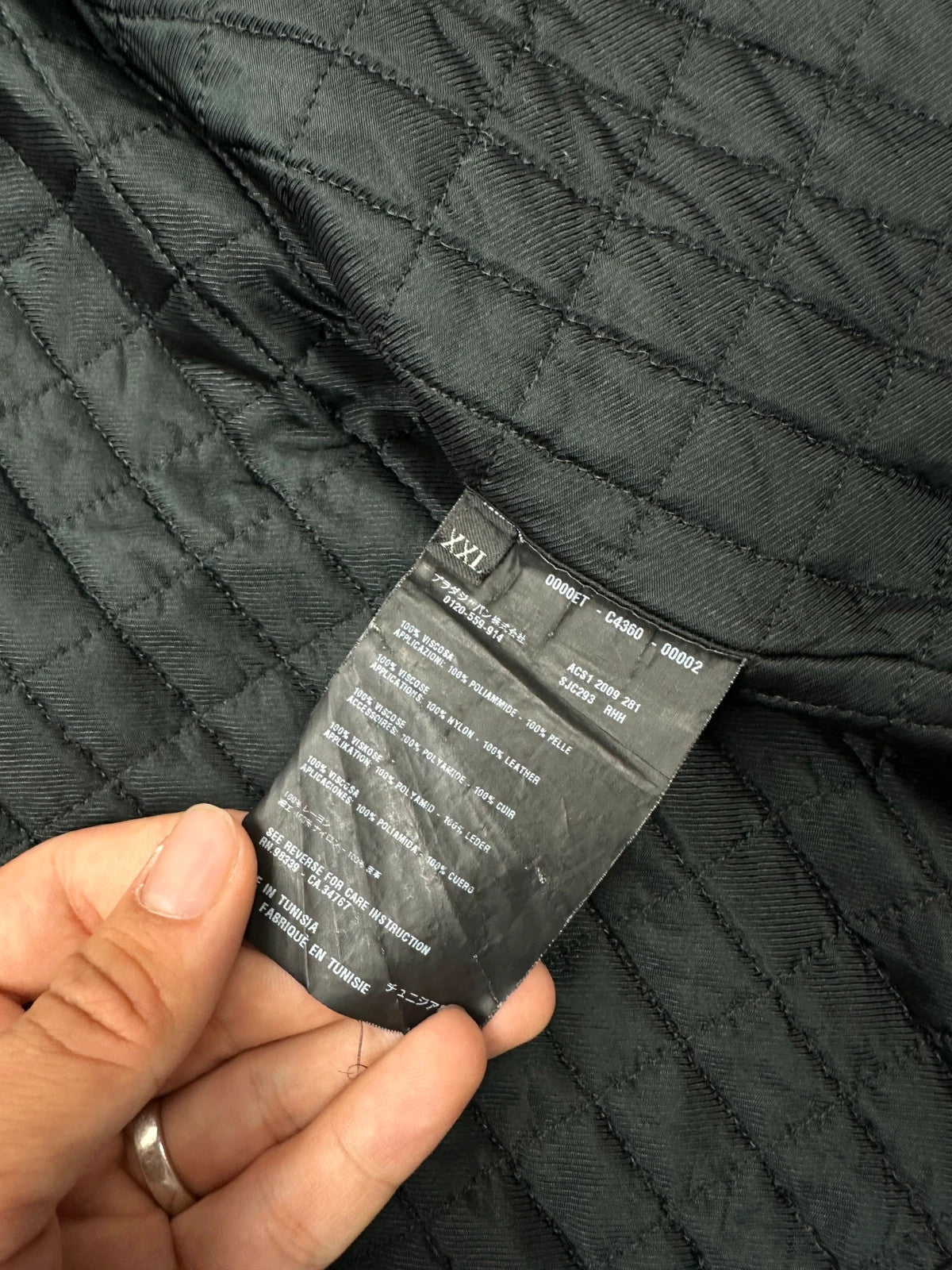 Prada black padded hooded jacket with 90s-inspired patch and braided drawstrings.