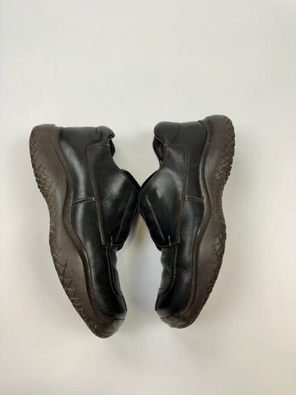Prada black leather Derby shoes with Vibram sole and Linearossa logo detail.