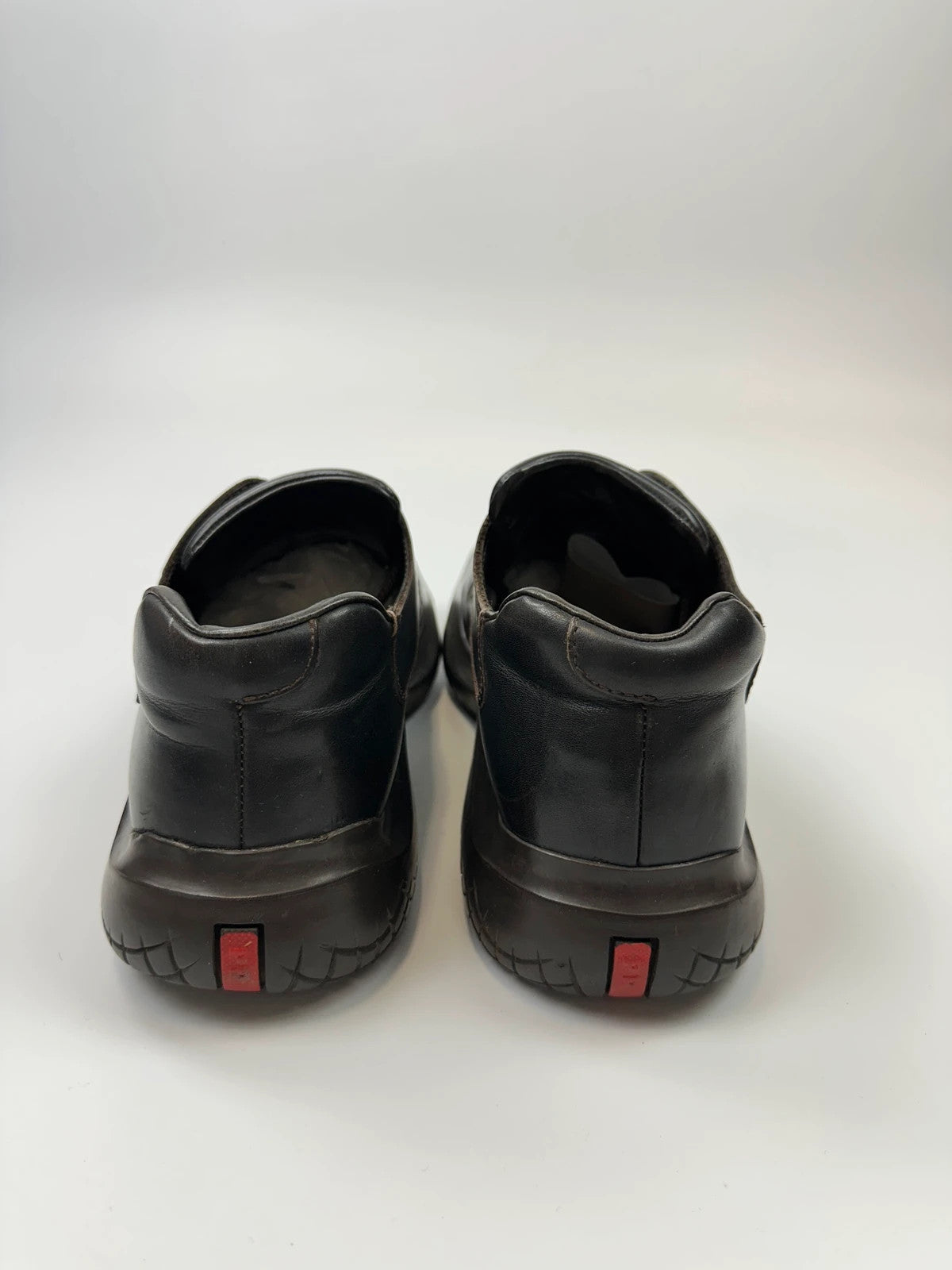 Prada black leather Derby shoes with Vibram sole and Linearossa logo detail.