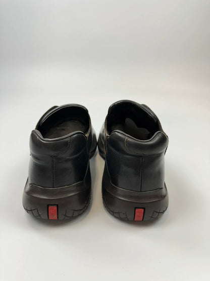 Prada black leather Derby shoes with Vibram sole and Linearossa logo detail.