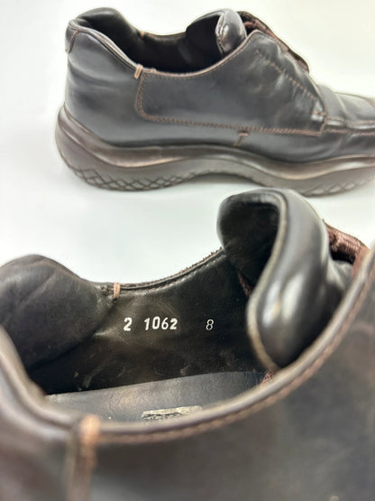 Prada black leather Derby shoes with Vibram sole and Linearossa logo detail.