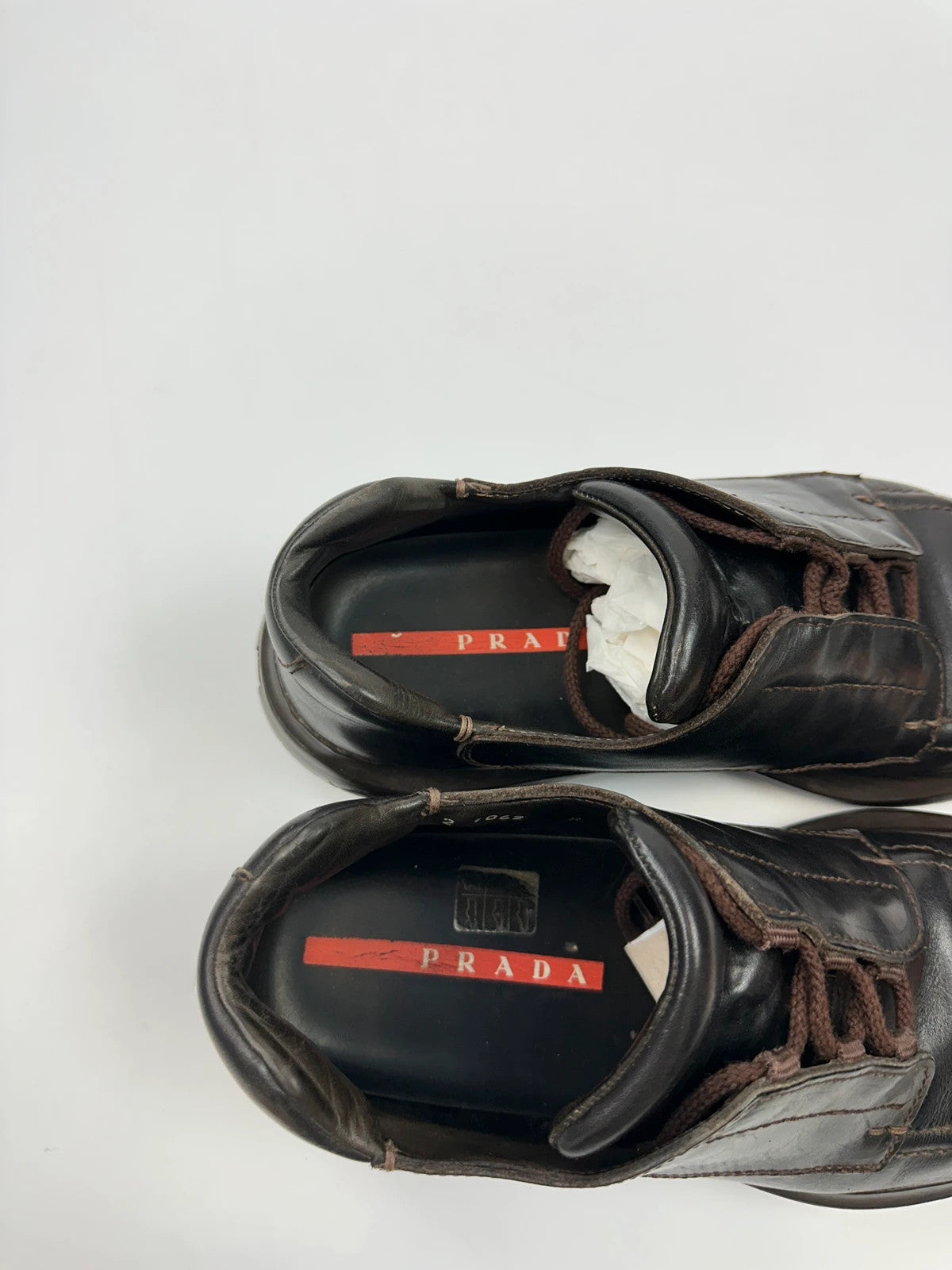 Prada black leather Derby shoes with Vibram sole and Linearossa logo detail.