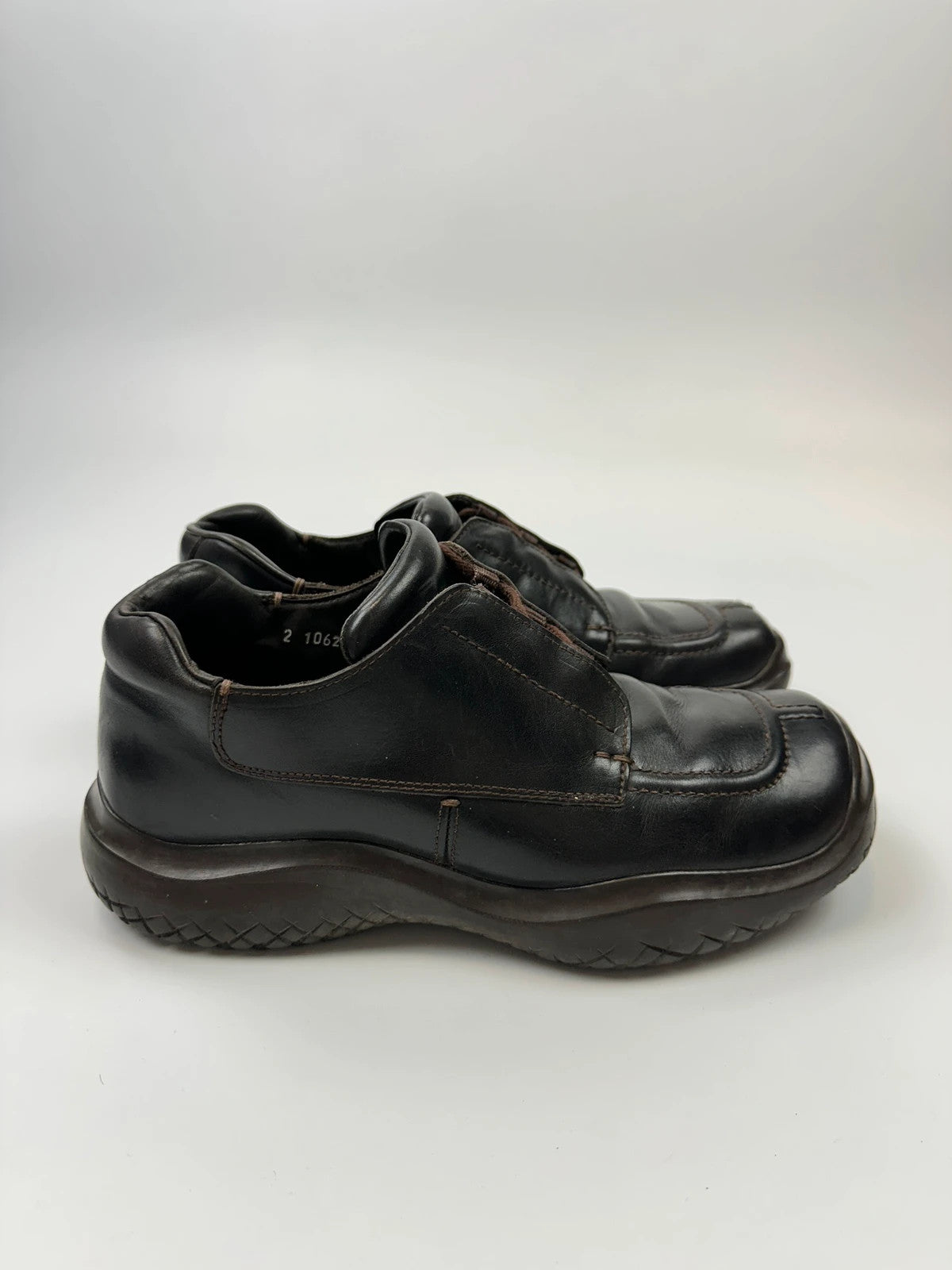 Prada black leather Derby shoes with Vibram sole and Linearossa logo detail.