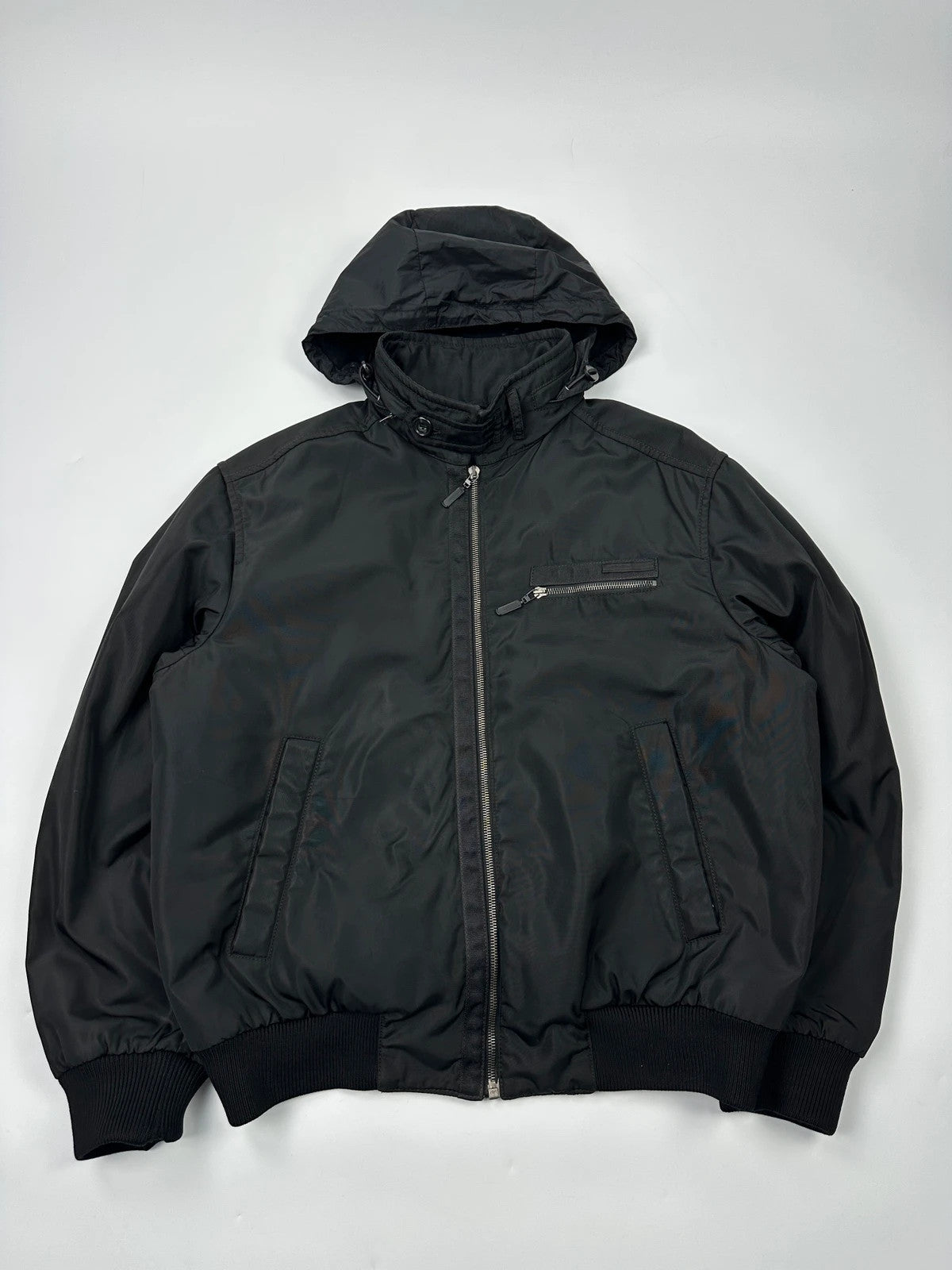 Prada black bomber jacket with hidden hood, minimalist design, luxury runway archive.