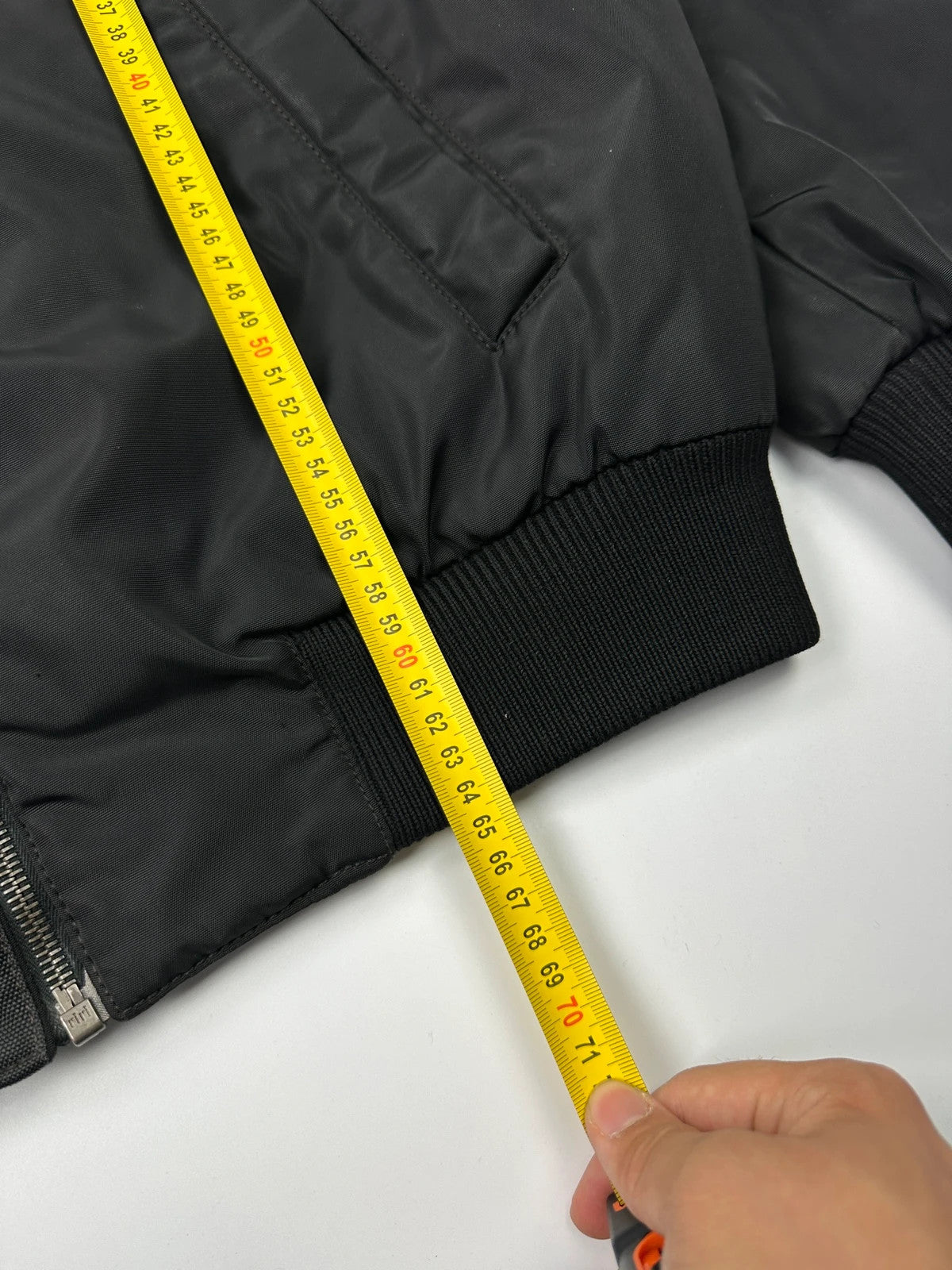 Prada black bomber jacket with hidden hood, minimalist design, luxury runway archive.