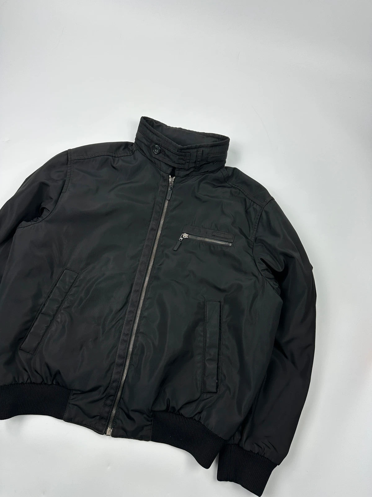 Prada black bomber jacket with hidden hood, minimalist design, luxury runway archive.
