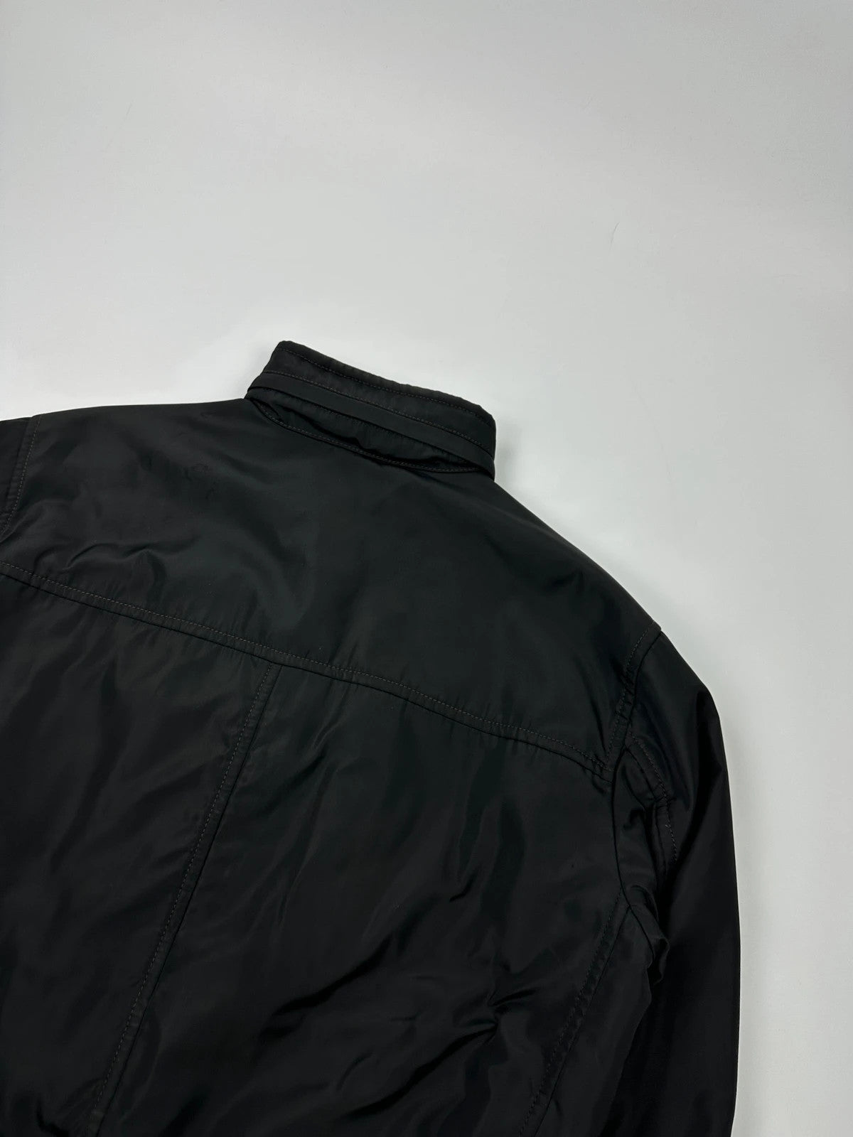 Prada black bomber jacket with hidden hood, minimalist design, luxury runway archive.