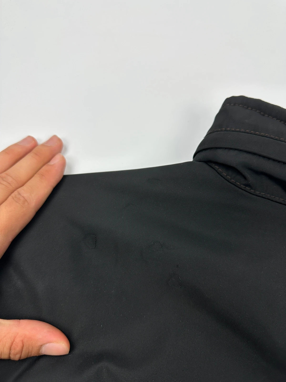 Prada black bomber jacket with hidden hood, minimalist design, luxury runway archive.