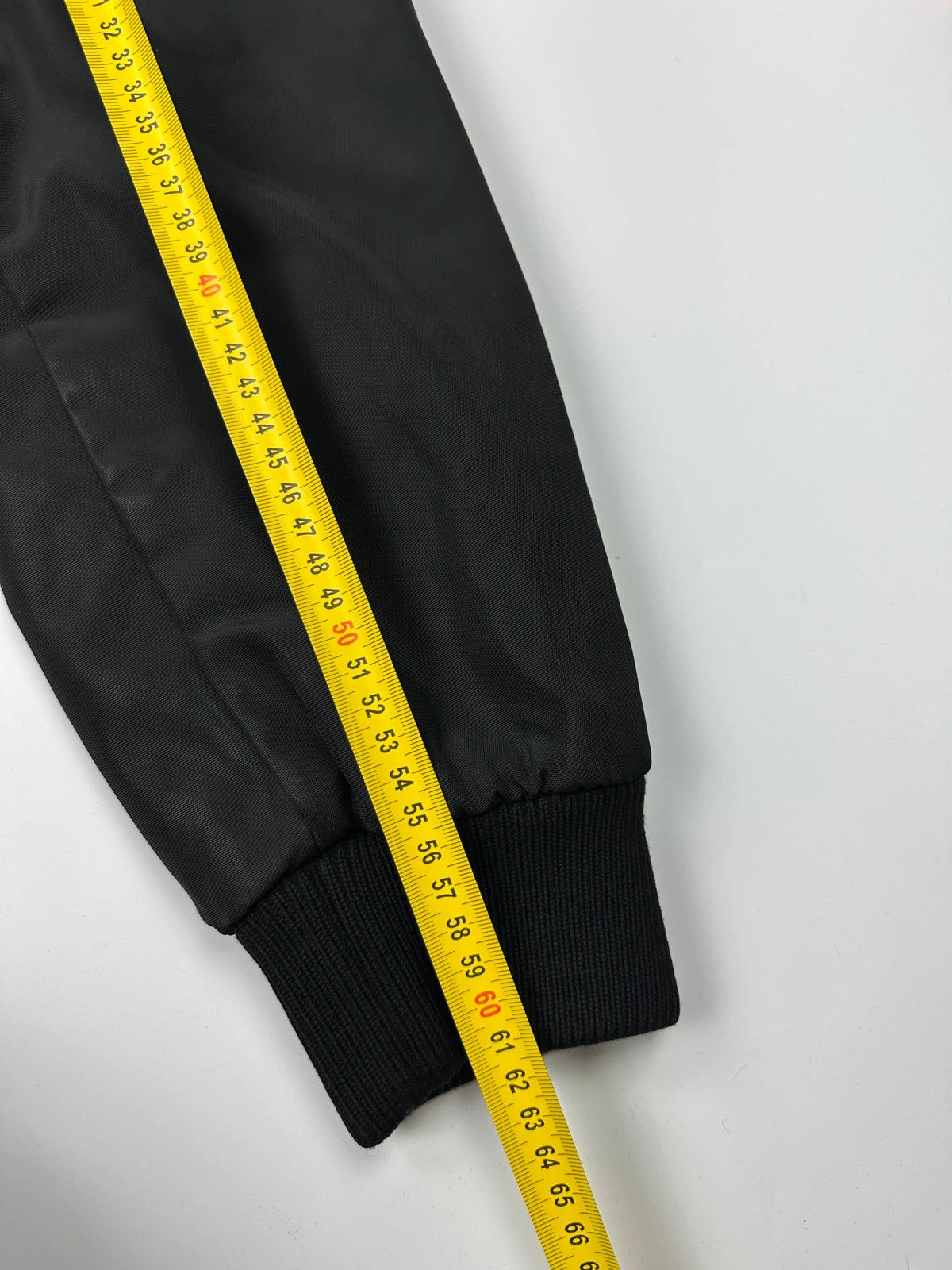 Prada black bomber jacket with hidden hood, minimalist design, luxury runway archive.