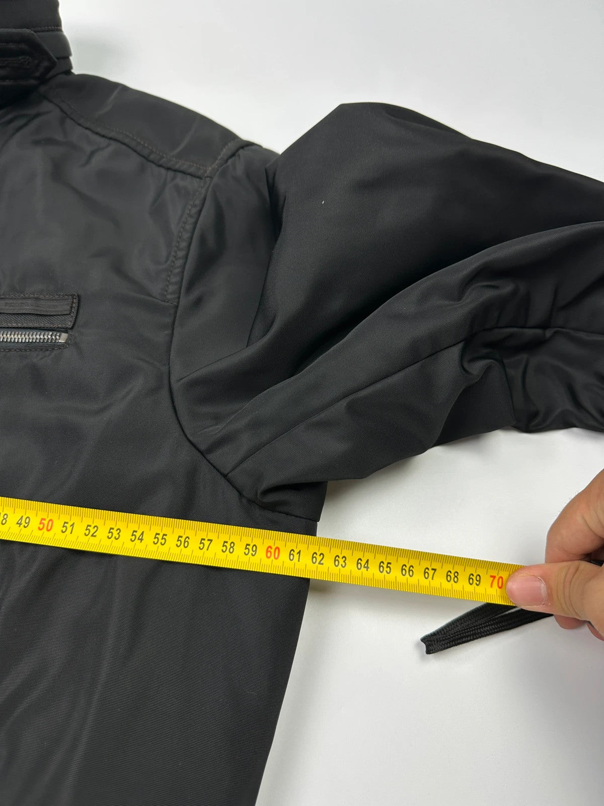 Prada black bomber jacket with hidden hood, minimalist design, luxury runway archive.