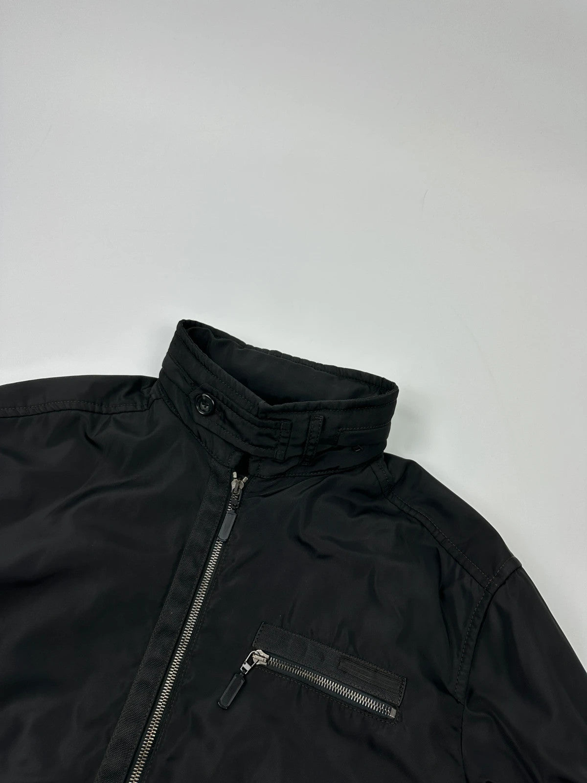 Prada black bomber jacket with hidden hood, minimalist design, luxury runway archive.