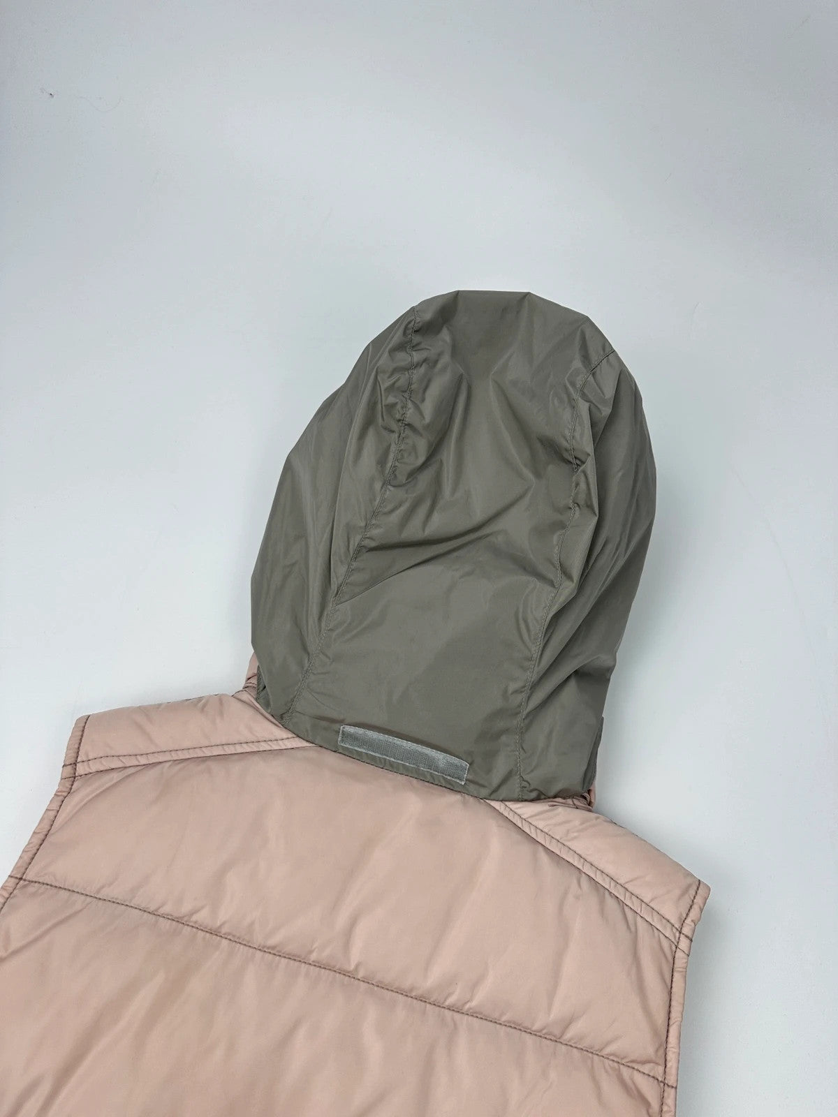 Prada orange and pink puffer vest with retractable hood and logo detailing.