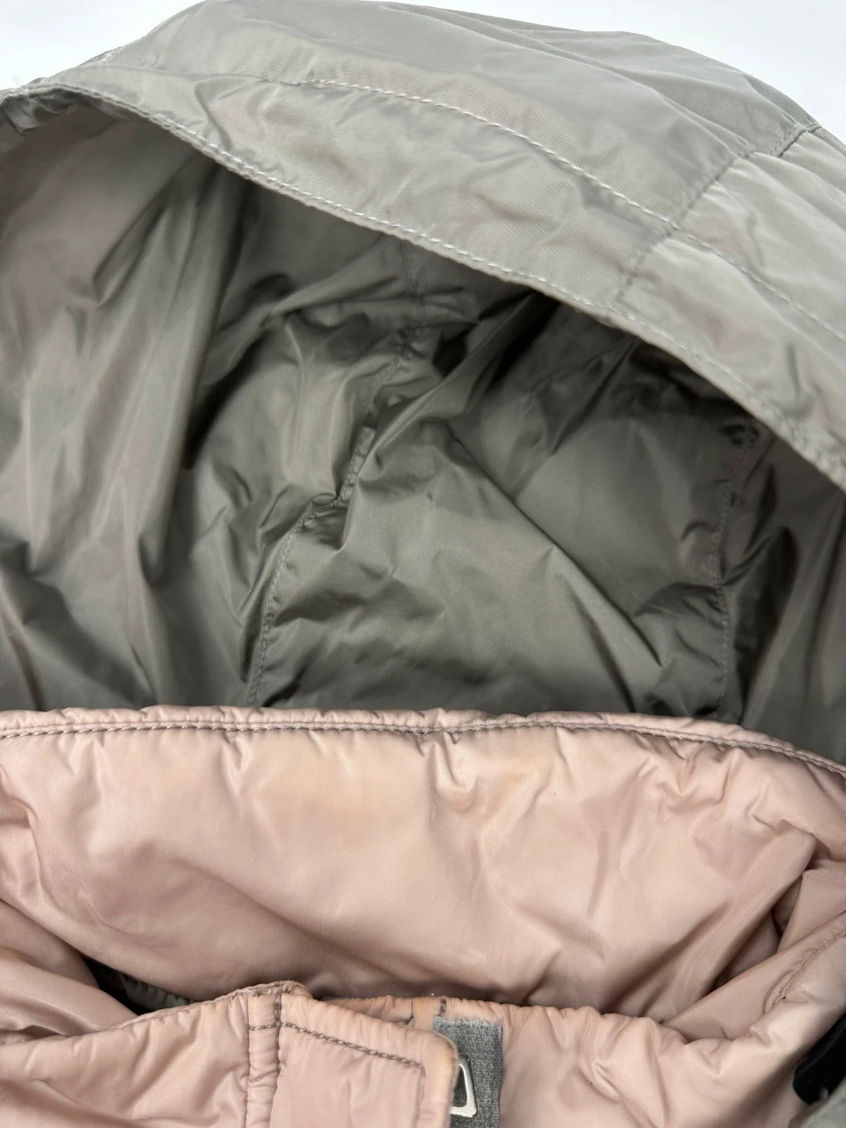 Prada orange and pink puffer vest with retractable hood and logo detailing.