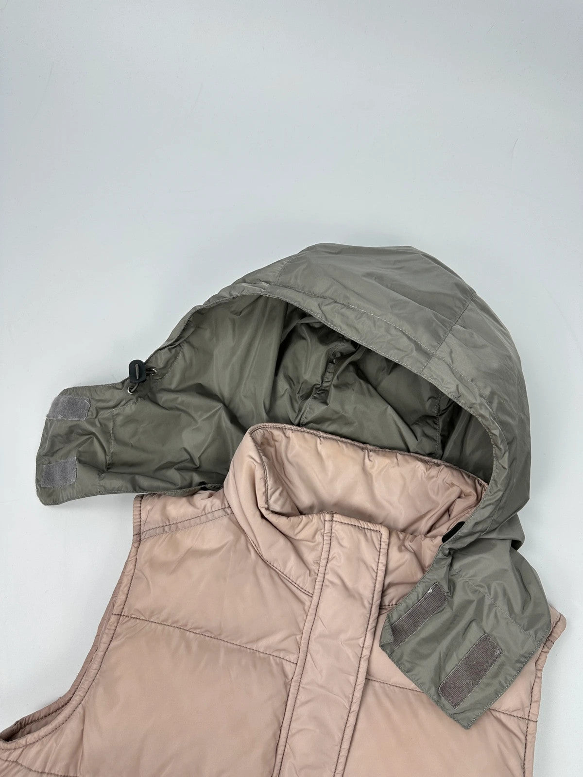Prada orange and pink puffer vest with retractable hood and logo detailing.