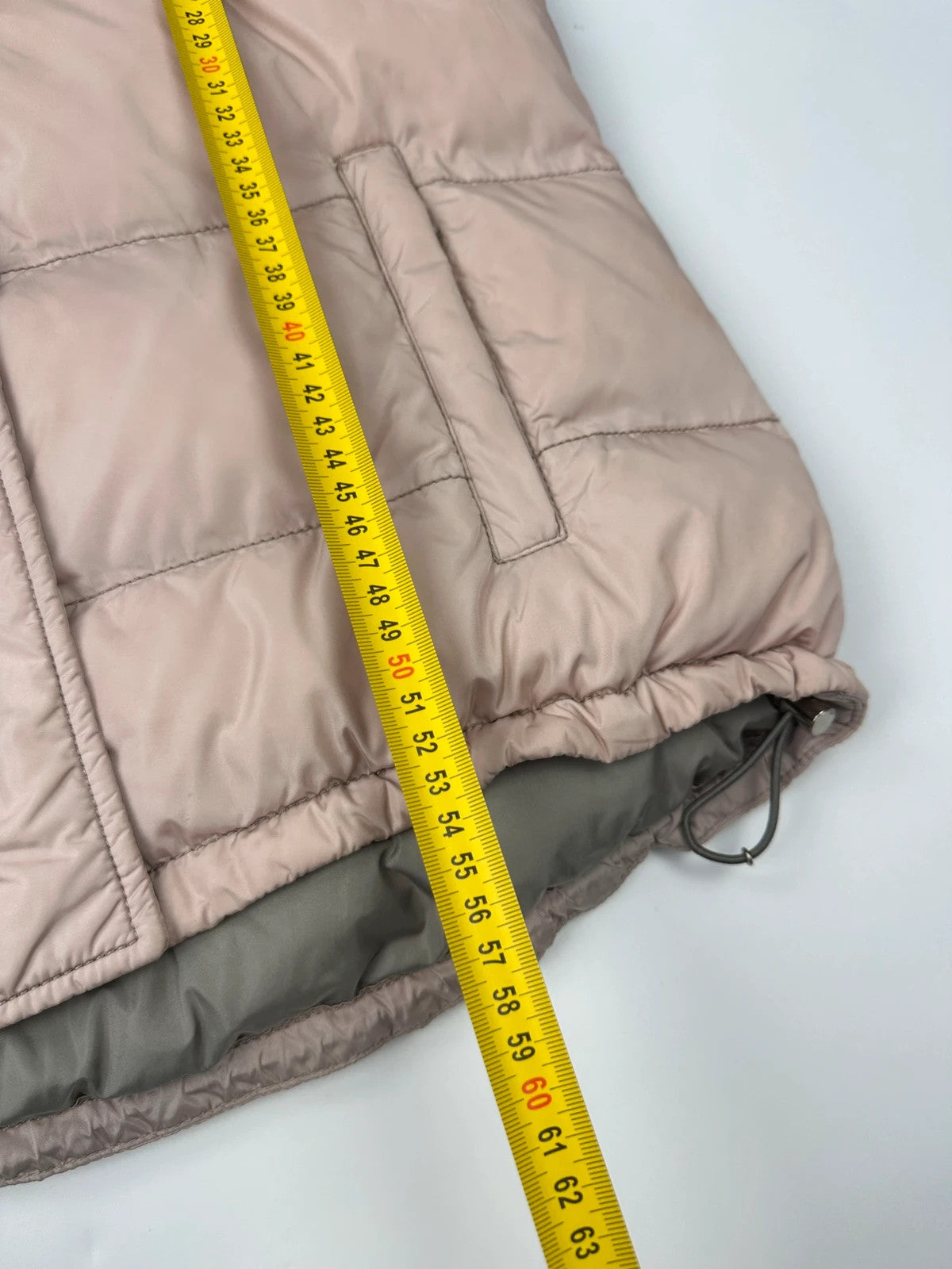 Prada orange and pink puffer vest with retractable hood and logo detailing.