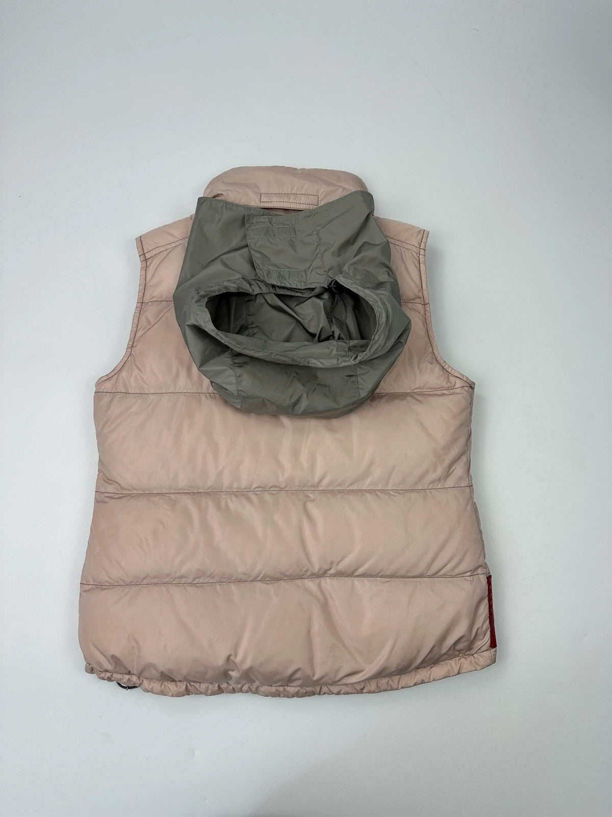 Prada orange and pink puffer vest with retractable hood and logo detailing.
