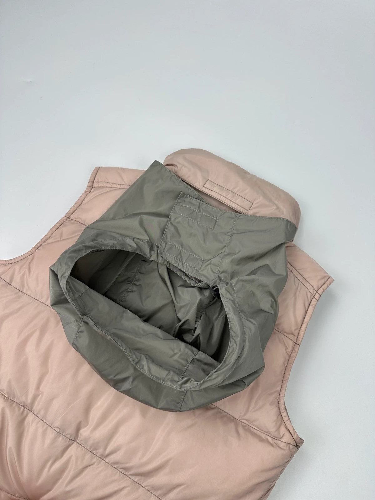 Prada orange and pink puffer vest with retractable hood and logo detailing.