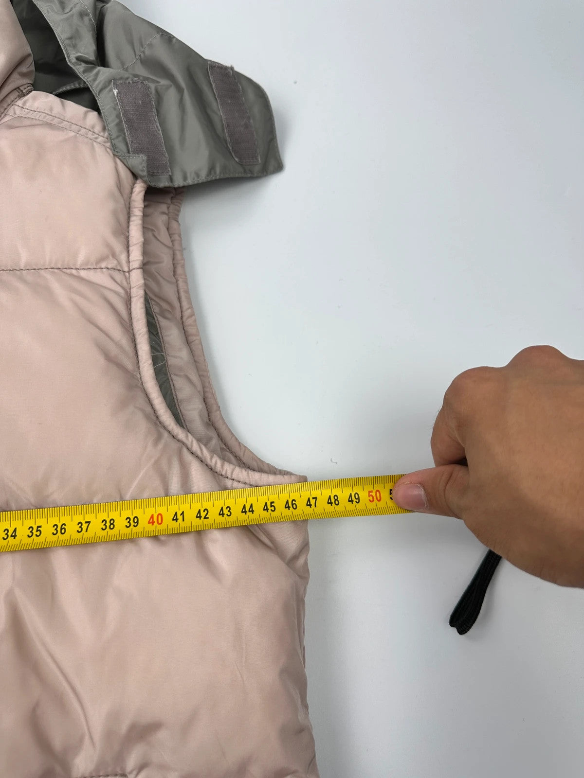Prada orange and pink puffer vest with retractable hood and logo detailing.