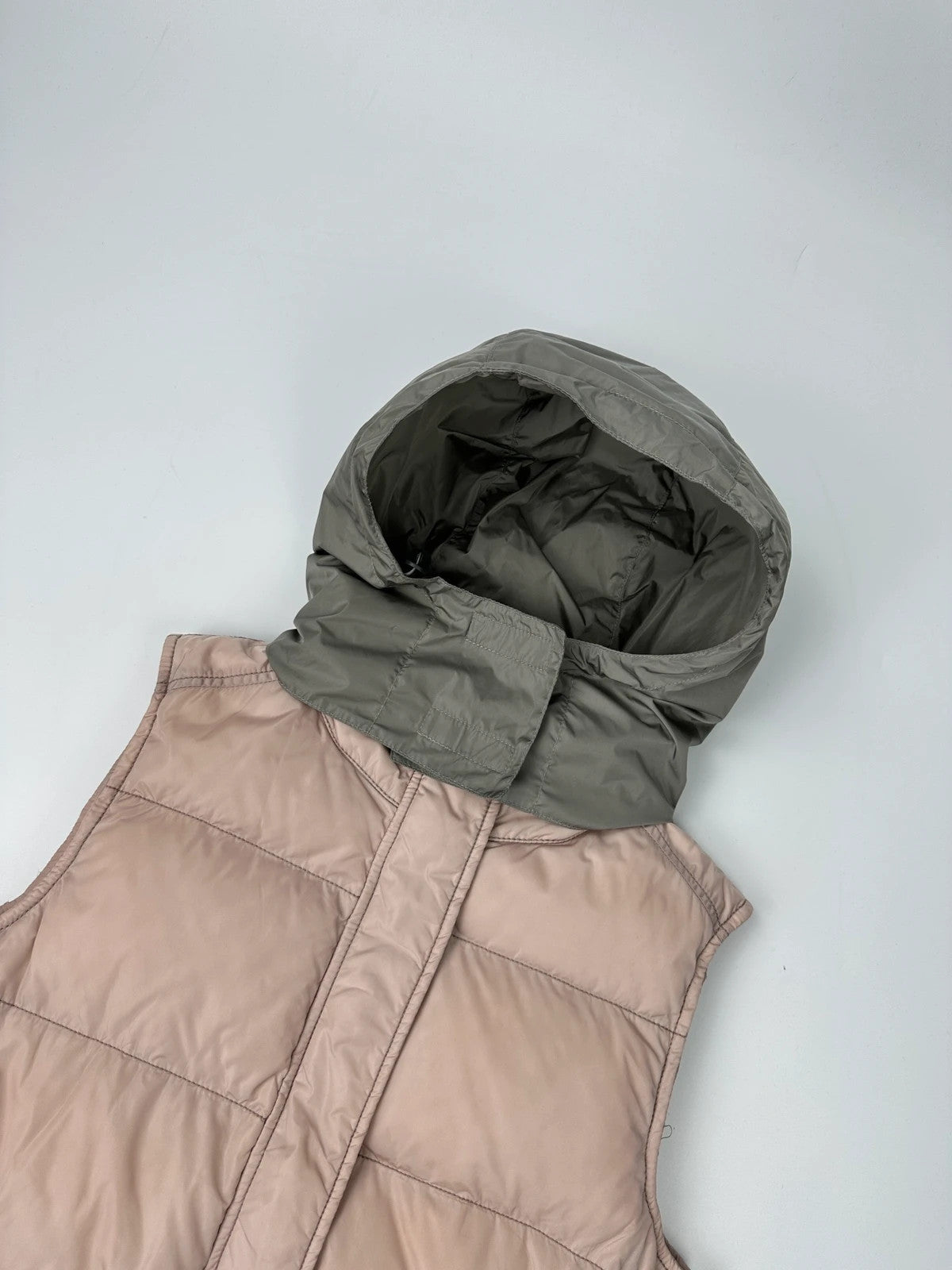 Prada orange and pink puffer vest with retractable hood and logo detailing.