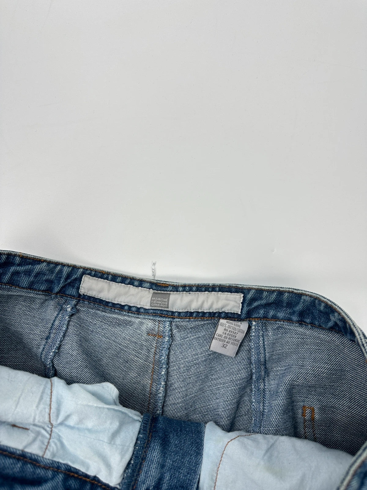 Marithé François Girbaud blue denim flared jeans with twisted design and vintage 90s style.
