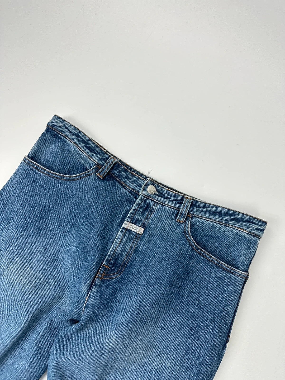 Marithé François Girbaud blue denim flared jeans with twisted design and vintage 90s style.