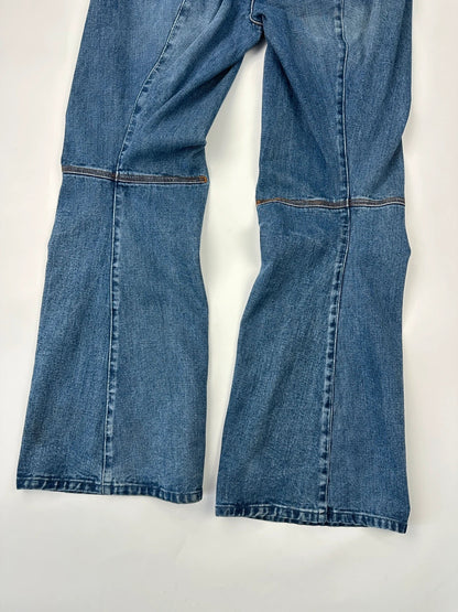 Marithé François Girbaud blue denim flared jeans with twisted design and vintage 90s style.